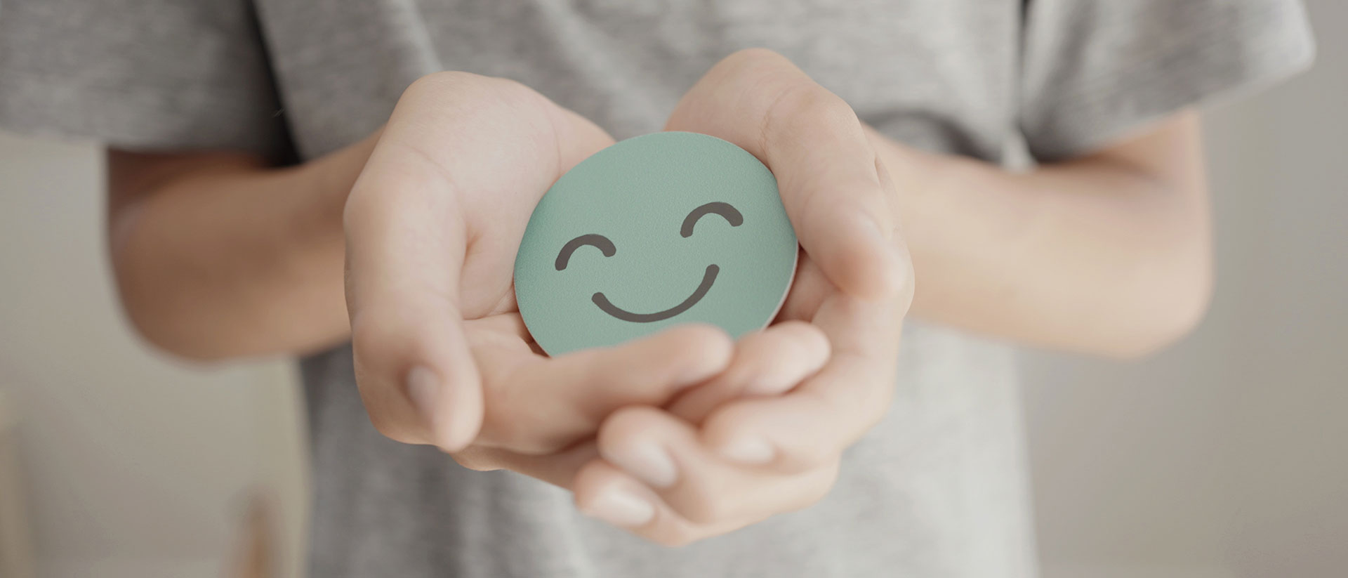 Child holding a light green chip with a print of a smile graphic